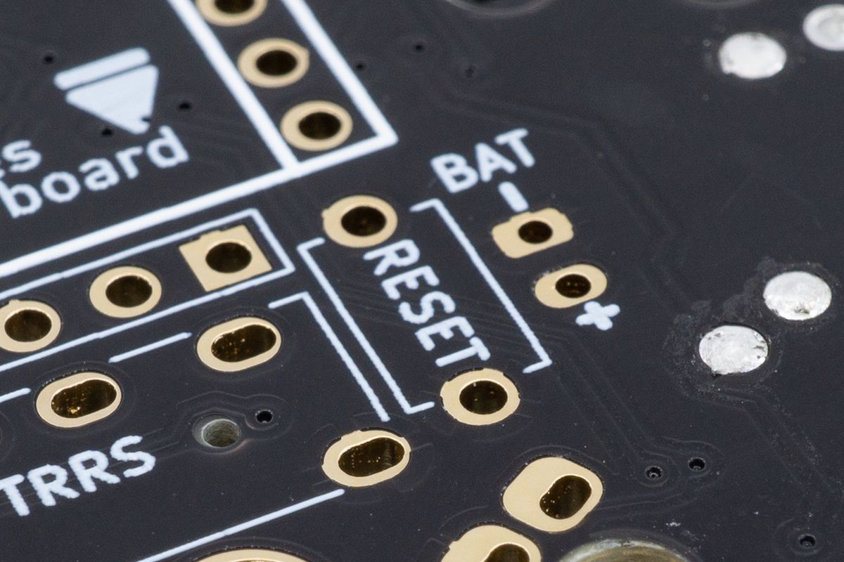 The footprint for the straight reset button, with its RESET text, two holes and rectangular outline