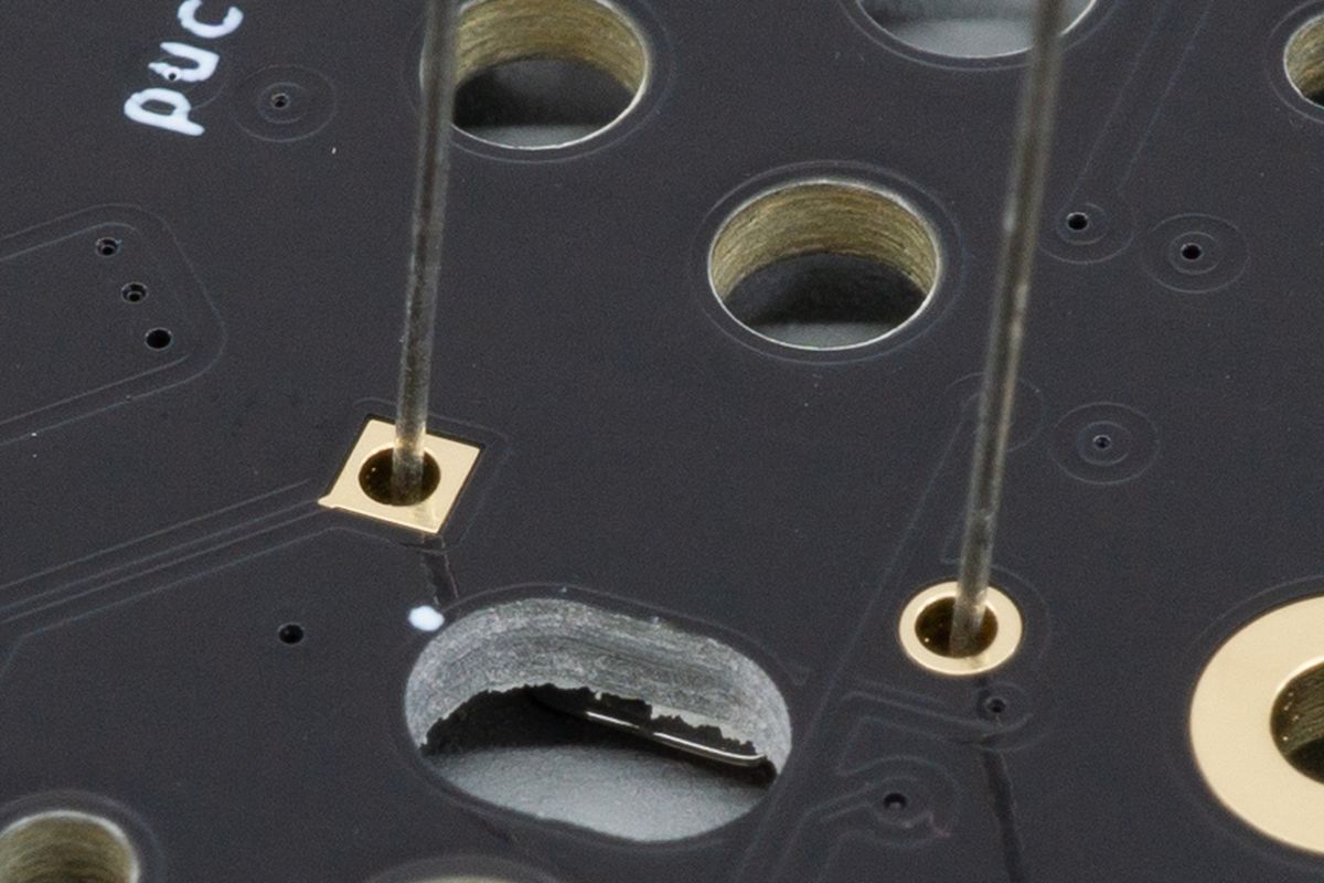 The leads of a through-hole diode sticking out of the top side of the PCB