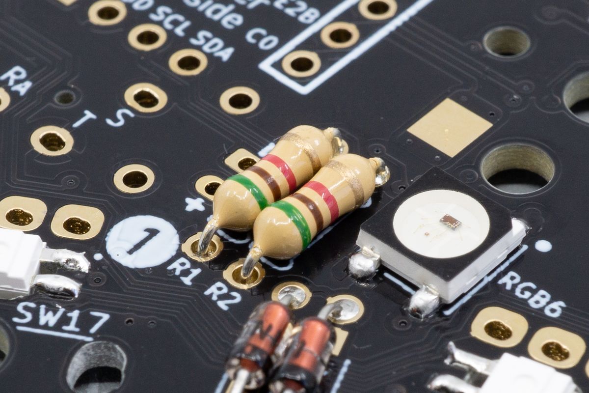 Two through-hole resistors inserted into their footprints