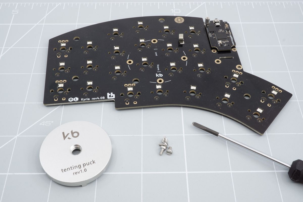 The tenting puck, the keyboard PCB and a flat head screwdriver