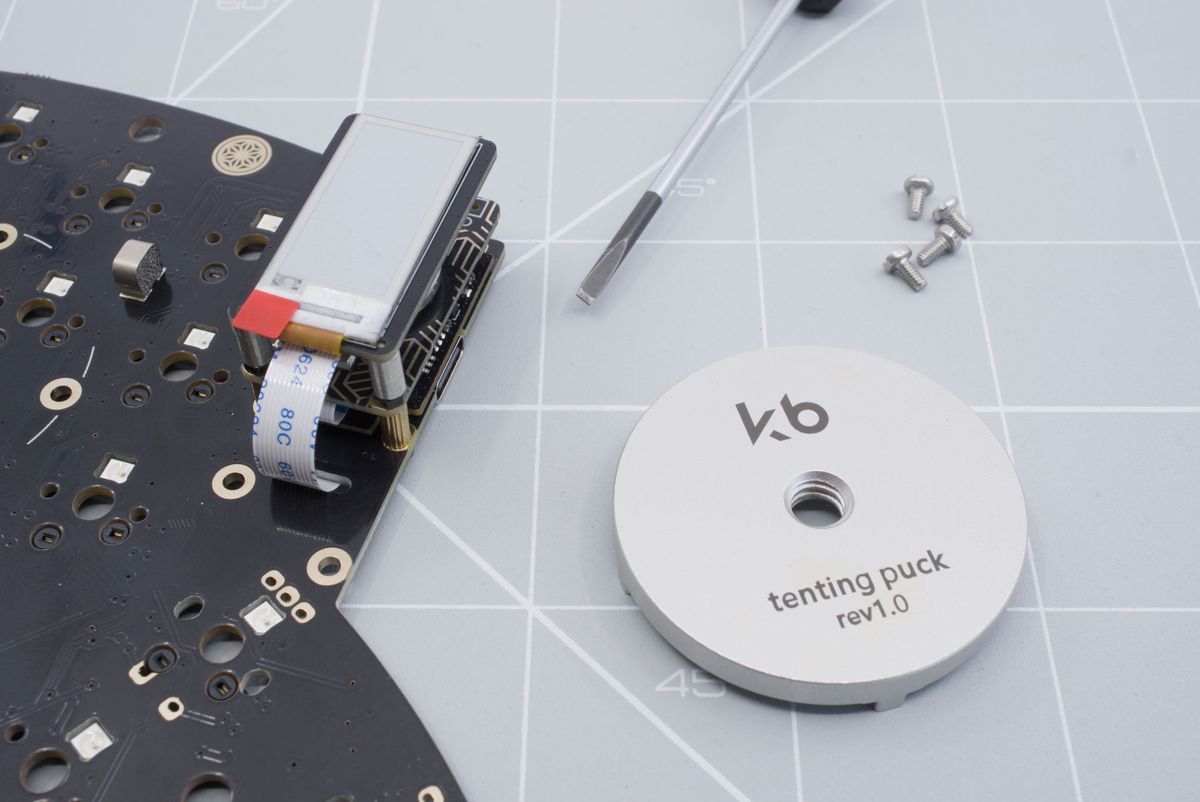 The tenting puck, the keyboard PCB and a flat head screwdriver