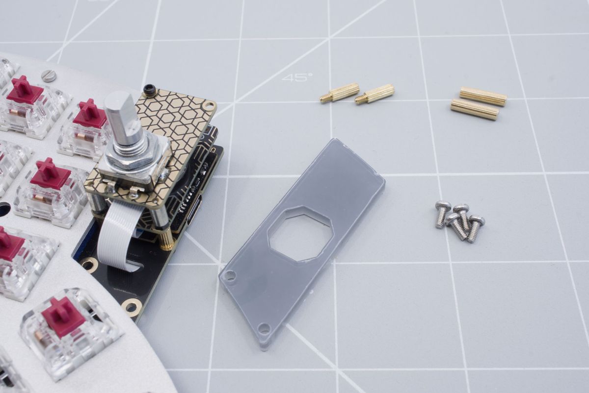 The keyboard, the cover, two 8mm male-to-female spacers, two 12mm spacers, four screws and a flat head screwdriver.