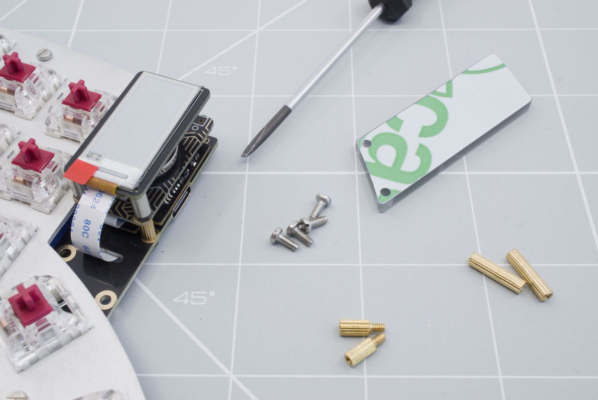 The keyboard, the cover, two 6mm male-to-female spacers, two 12mm spacers, four screws and a flat head screwdriver.
