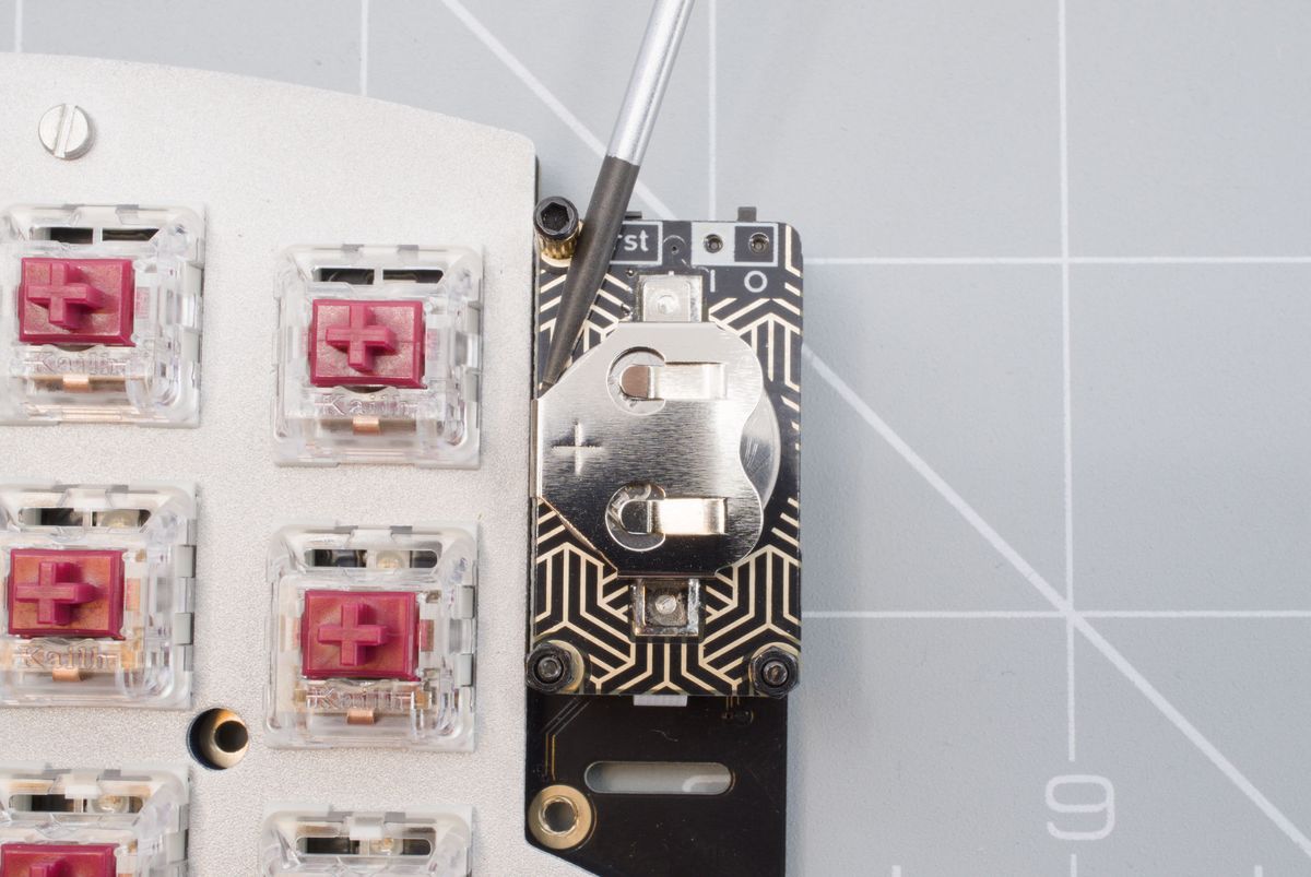 Pushing the coin cell battery out using a screwdriver